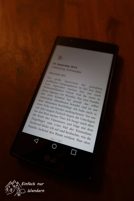 Der Smartphone Bildschirm zeigt eine Seite des Buches Wandern, Radeln, Paddeln.
